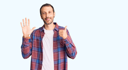 Young handsome man wearing casual clothes showing and pointing up with fingers number six while smiling confident and happy.