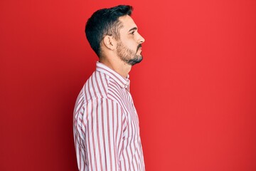 Young hispanic man wearing business shirt looking to side, relax profile pose with natural face with confident smile.