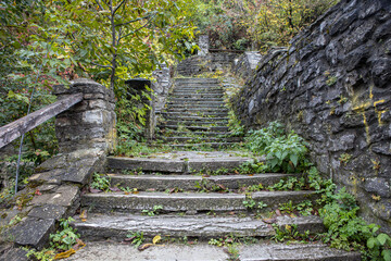 Old ancient stone staircase with yellow fallen leaves