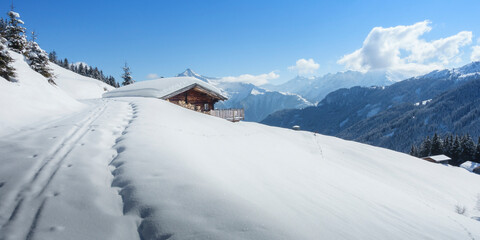Fototapeta na wymiar Panorama einer Winterlandschaft mit Skihütte in den Alpen