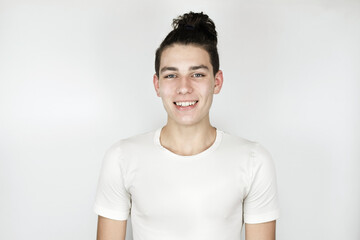 Portrait of an optimistic cheerful teenager boy on a light background, the boy has a beautiful smile and healthy white teeth