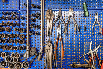 A SERIES OF MECHANICAL TOOLS INCLUDING VARIOUS PLIERS, SOCKET WRENCHES, SCISSORS AND EXTRACTORS.