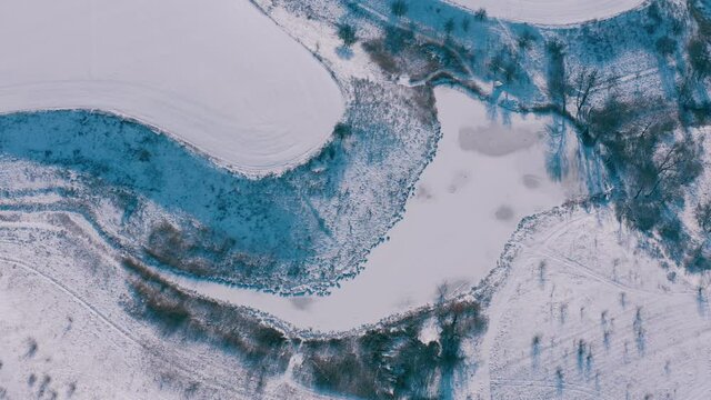 top view of a mysterious scary winter lake, a strange place with unusual energy in the green northern forests. Topshot - Aerial Flight 