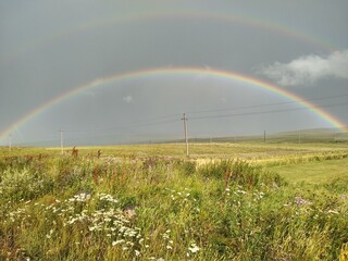 Vibrant double rainbow over a field