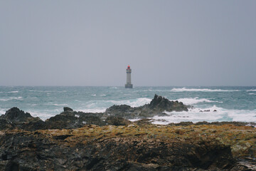 red lighthouse in the ocean. Brittany, France