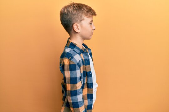 Little caucasian boy kid wearing casual clothes looking to side, relax profile pose with natural face with confident smile.