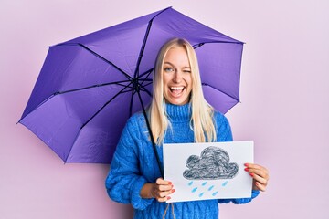 Young blonde girl holding umbrella rain draw winking looking at the camera with sexy expression,...