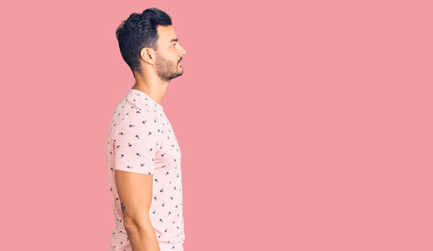 Young handsome hispanic man wearing casual clothes looking to side, relax profile pose with natural face with confident smile.