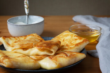 A dish for a full breakfast pancakes with milk stuffed with fresh cottage cheese with sour cream and honey.