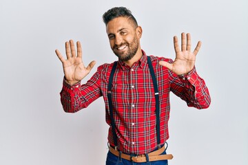 Fototapeta premium Handsome man with beard wearing hipster elegant look showing and pointing up with fingers number ten while smiling confident and happy.