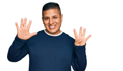 Young latin man wearing casual clothes showing and pointing up with fingers number nine while smiling confident and happy.