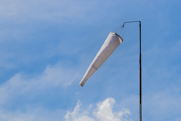 Windsock blowing against lightly cloudy sky - Room for text.