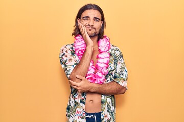 Young handsome man wearing swimwear and hawaiian lei thinking looking tired and bored with...