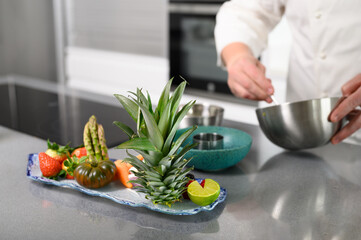 Male Chef preparing fine organic dining with vegetables and Fruit. Chef Cooking Healthy Vegetables. Dieting Culinary Food. High quality photo