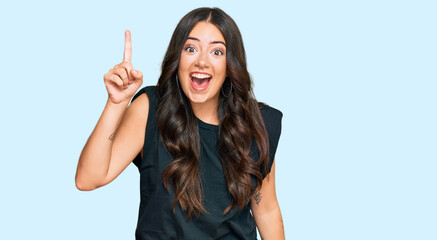 Obraz premium Beautiful brunette young woman wearing black shirt pointing finger up with successful idea. exited and happy. number one.