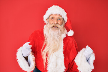 Old senior man with grey hair and long beard wearing traditional santa claus costume excited for success with arms raised and eyes closed celebrating victory smiling. winner concept.