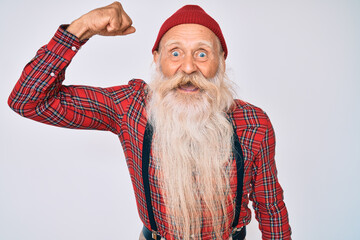 Old senior man with grey hair and long beard wearing hipster look with wool cap angry and mad...