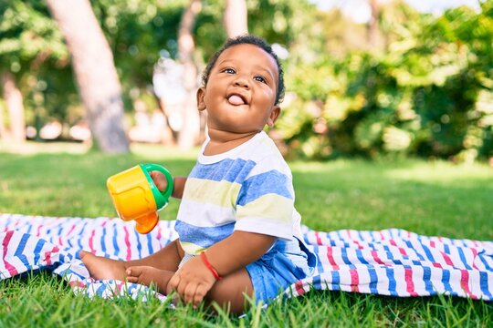 Adorable african american toddler smiling happy playing with toy at the park.