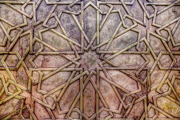 Fototapeta na wymiar Intricate tile patterns, metal work and plaster carvings adorning building exteriors in Fez Morocco