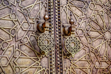Fototapeta na wymiar Intricate tile patterns, metal work and plaster carvings adorning building exteriors in Fez Morocco