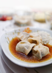 Traditional polish Christmas Supper - delicious dumplings stuffed mushrooms with borsh on a white plate. Selective focus