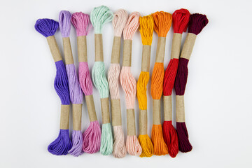 colorful embroidery threads on a white background. needlework