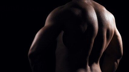 Fototapeta na wymiar Fit and sporty bodybuilder over black background. Sportsman in studio. Sport and fitness concepts.