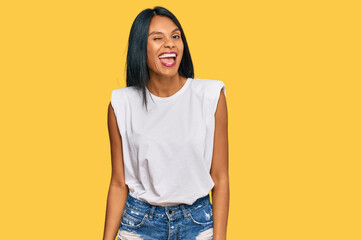 Young african american woman wearing casual clothes winking looking at the camera with sexy expression, cheerful and happy face.