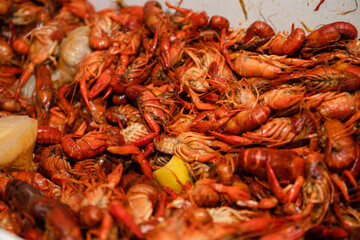 overhead closeup view of a large quantity of cooked crawfish ready to eat at a crawfish boil party...