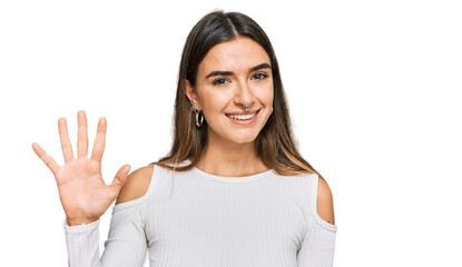 Young hispanic woman wearing casual clothes showing and pointing up with fingers number five while smiling confident and happy.