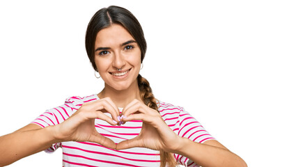 Young hispanic woman wearing casual clothes smiling in love doing heart symbol shape with hands. romantic concept.