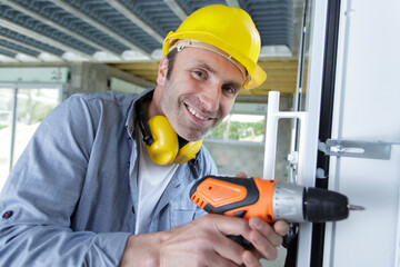 happy man drilling the wall with drill perforator