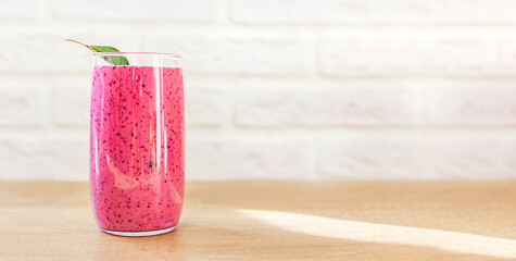 Tasty smoothie of almond or oat milk and berries in a glass glass on the table. Smoothie diet, slimming detox drink. The concept of a healthy lifestyle, proper nutrition, vegetarianism. Copy space.