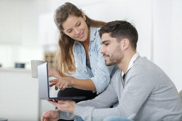relaxed couple looking at a laptop in the home