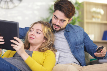 happy young couple relaxing at home with a tablet