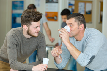 two men had conversation while drinking coffee