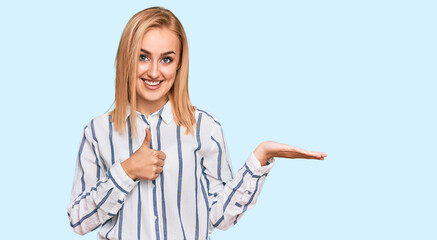 Beautiful caucasian woman wearing casual clothes showing palm hand and doing ok gesture with thumbs up, smiling happy and cheerful