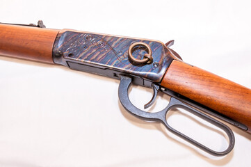 A lever action 30-30 caliber hunting rifle with a saddle ring attached on a white background