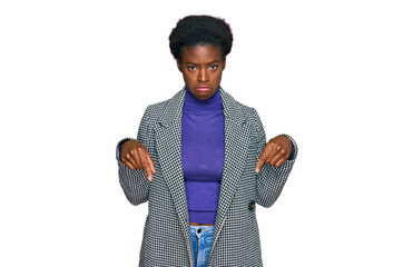 Young african american girl wearing casual clothes pointing down looking sad and upset, indicating...