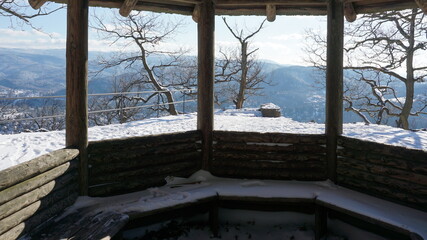 the view from the inside of a wooden pavilion on the snowy Ritterplatte (knight plate) at the Battert, a panorama path in Baden-Baden in the region Baden-Wuerttemberg, Germany