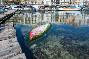 Obraz premium Traditional boat sunk in the harbor, Marsaxlokk, Malta