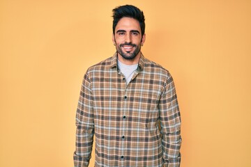 Obraz premium Handsome hispanic man with beard wearing casual clothes with a happy and cool smile on face. lucky person.
