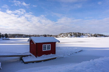 Small wooden cabin little house in the middle of the water of lake or sea bay. Bath house or sauna...