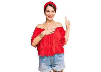 Young brunette woman with short hair wearing casual summer clothes and diadem smiling swearing with...