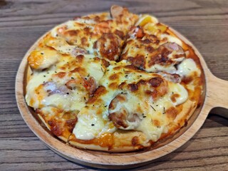 Delicious homemade pizza served on wooden tray.