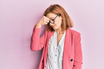 Young caucasian woman wearing business style and glasses tired rubbing nose and eyes feeling fatigue and headache. stress and frustration concept.