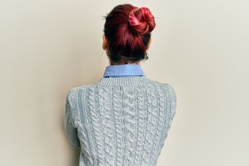 Young caucasian woman wearing casual clothes and glasses standing backwards looking away with...