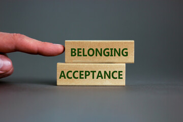 Acceptance and belonging symbol. Wooden blocks with words 'acceptance and belonging' on beautiful grey background. Businessman hand. Business, acceptance and belonging concept. Copy space.