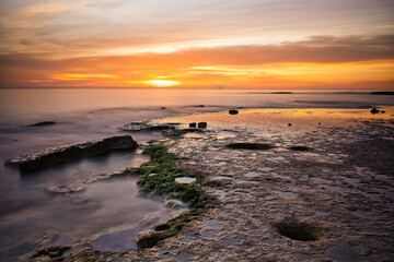 beautiful sunrise on the beach with rocks and very colorful on the beach of Alicante, Spain