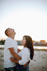 Obraz premium love couple guy and girl hugging and laughing at sunset